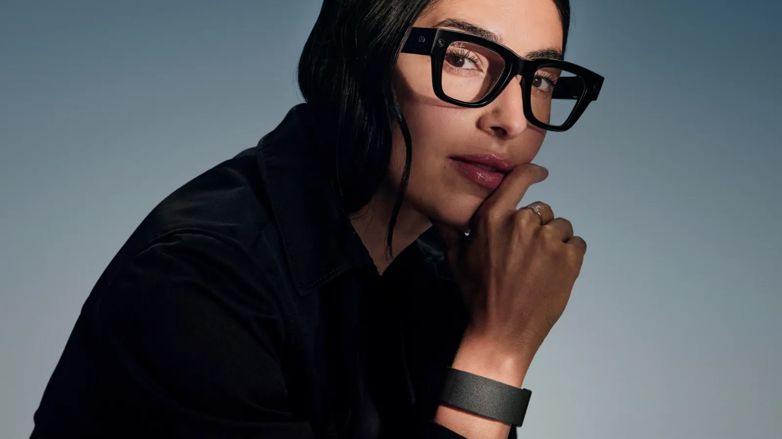 Person wearing Meta Ray-Ban Display glasses with the Meta Neural Band on the wrist